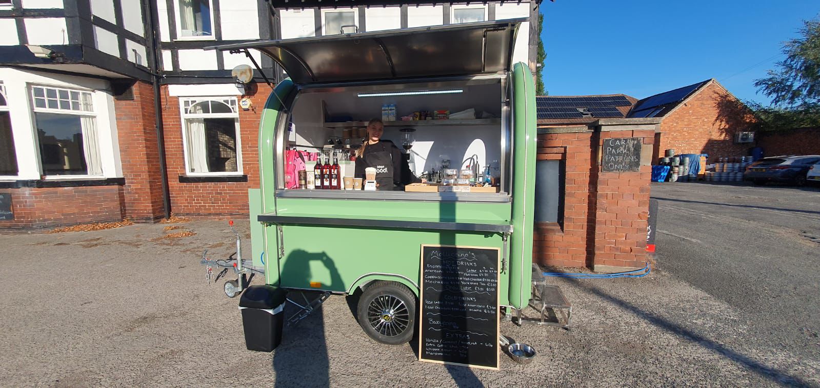 Side view of the Molliccino's sage green trailer on a sunny day