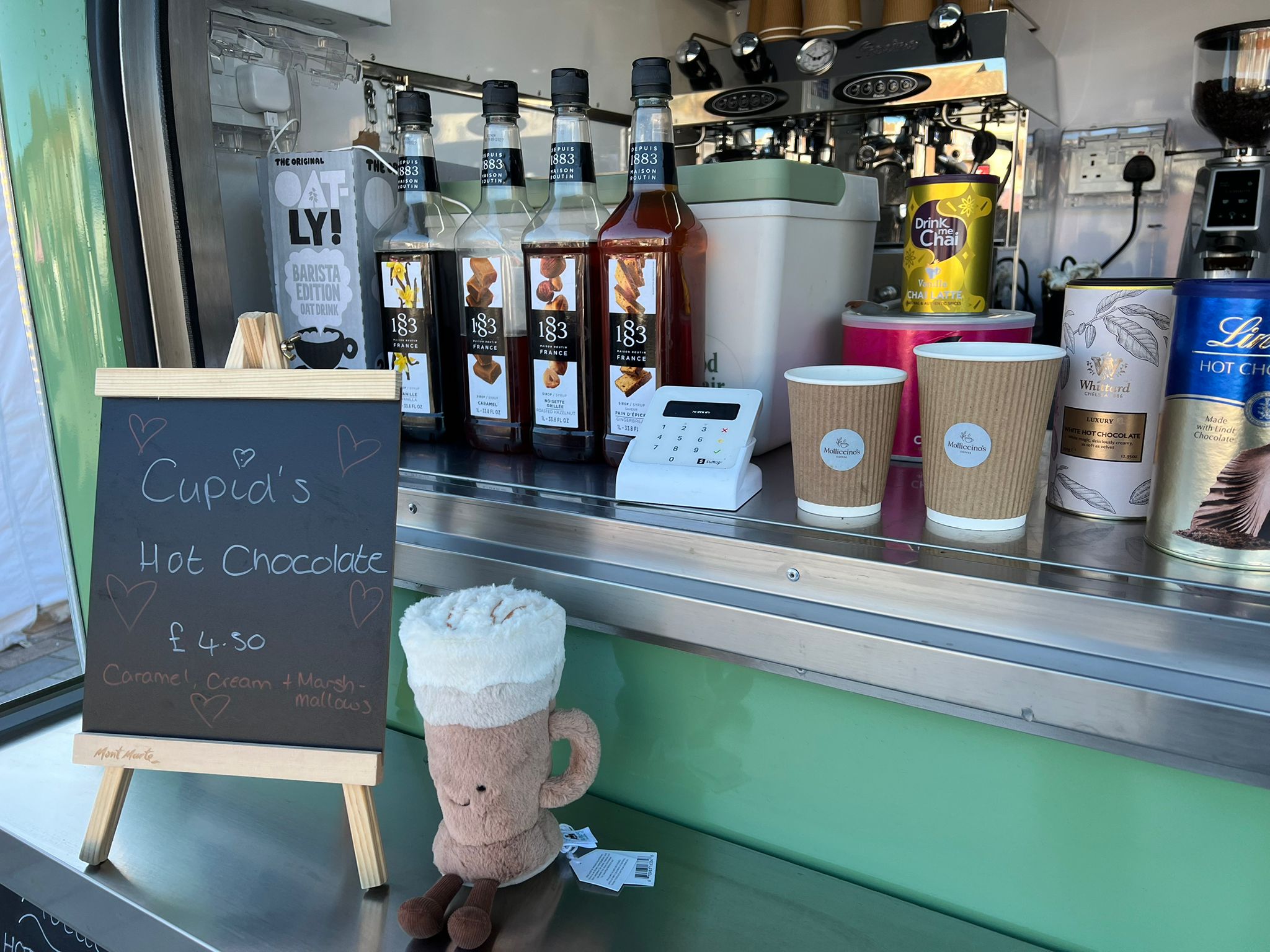 Cupid's Hot Chocolate seasonal special chalkboard sign with a cute plush toy